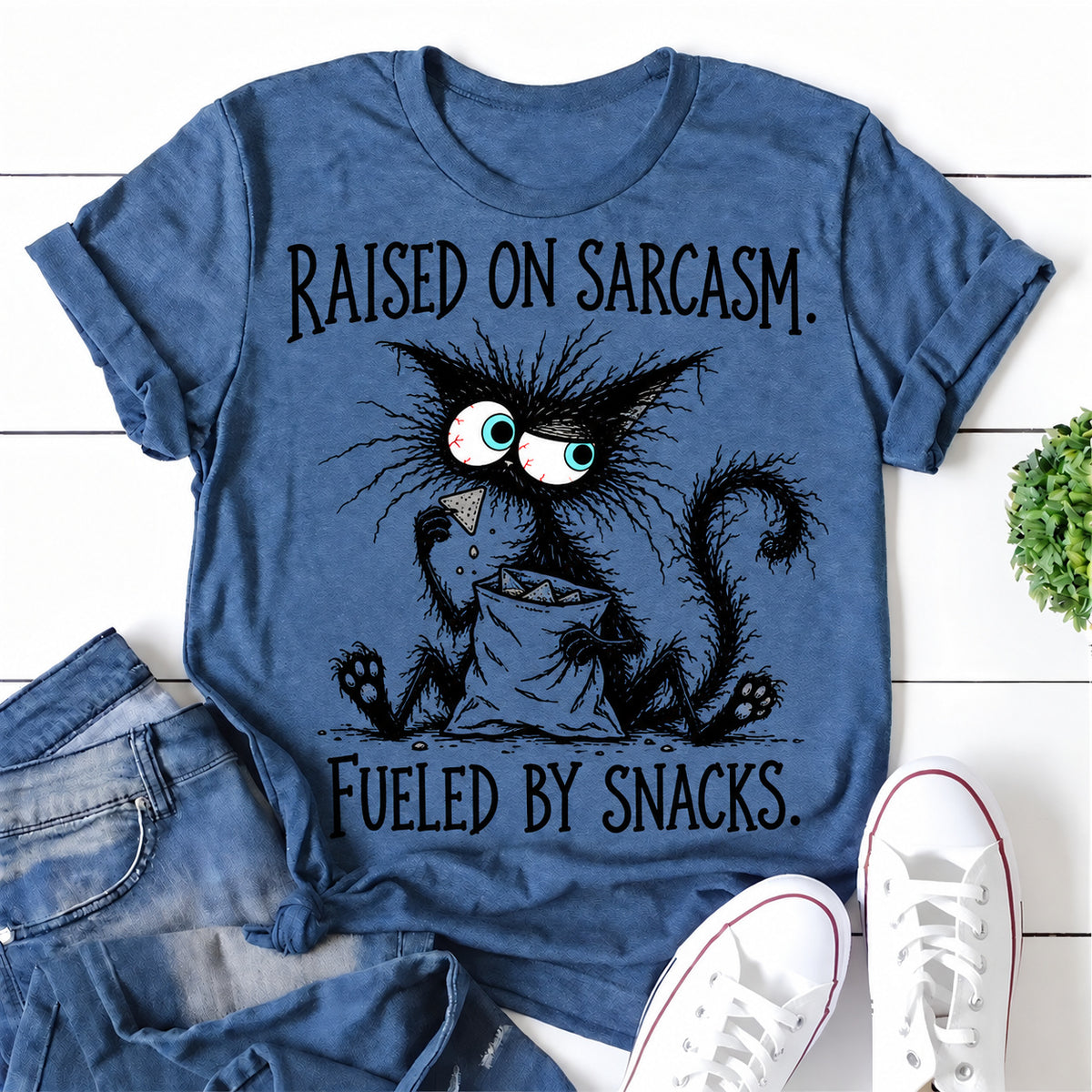 Blue women's T-shirt with Raised On Sarcasm. Fueled By Snacks graphic